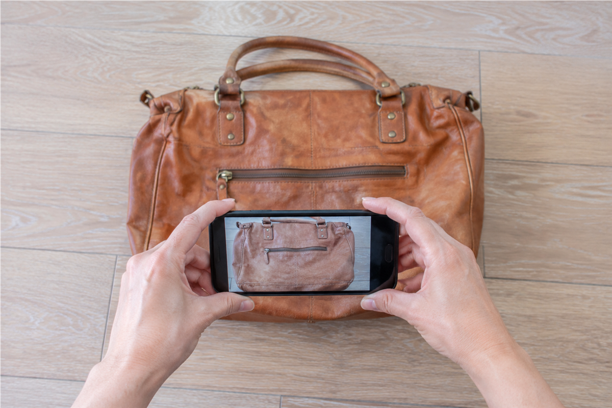 バッグ全体とファスナーの停止位置をスマートフォンで撮影する様子